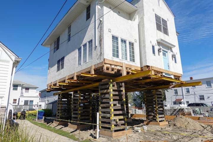 A team of professionals using specialized equipment to raise a house in Lakeland, preparing it for elevation and renovation